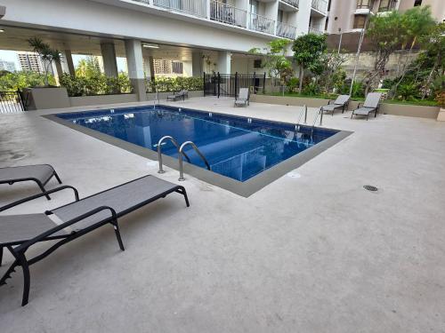 a swimming pool in a building with benches and chairs at Waikiki Vacation Condo in Honolulu