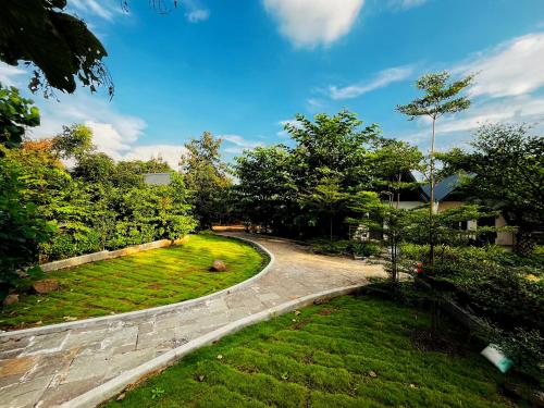 a winding road in a yard with trees and grass at Birds Nest Resort in Kinlivli