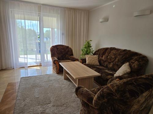 a living room with two couches and a coffee table at Domki na skarpie in Tarnobrzeg