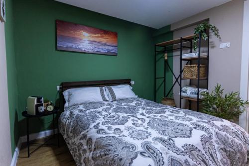 a bedroom with a bed and a green wall at Fata morgana Hostel in Beer Sheva