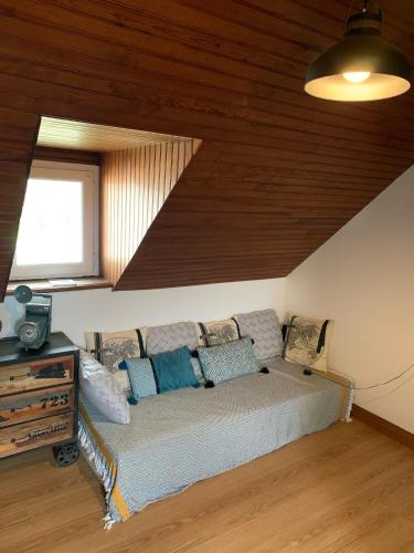 a bed in a room with a wooden ceiling at Gîte Ty Mamm Gozh in Peumérit