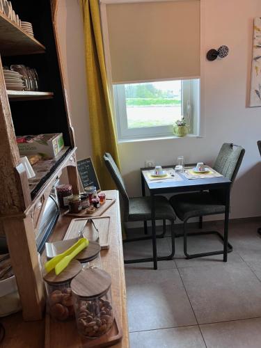 una cocina con mesa y sillas y una ventana en L'auberge du canal, en Brebotte