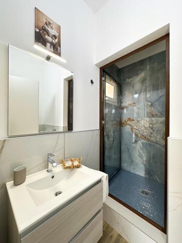 a bathroom with a sink and a shower at Tina House in Siculiana