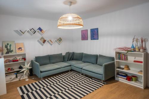 ein Wohnzimmer mit einem blauen Sofa und einem Teppich in der Unterkunft Spacious apartment Near National Arena, park in Bukarest