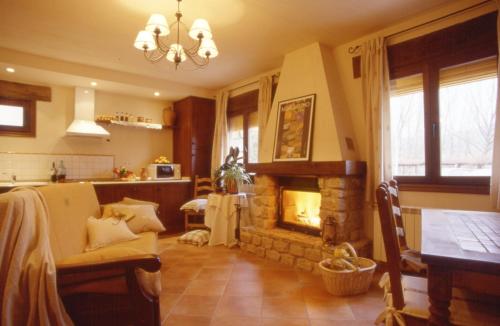 een woonkamer met een open haard en een tafel bij Casa Rural Nelia in Villalba de la Sierra