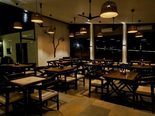 a restaurant with wooden tables and chairs and lights at Birds Nest Resort in Kinlivli