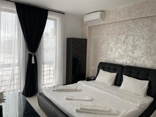 a bedroom with a large bed with two shoes on it at Beach Rooms Roberta in Mamaia