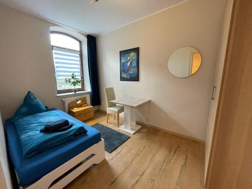 a small bedroom with a bed and a table at Gemütlich & Zentral - Familien-Oase mit Balkon,Waschmaschine, Trockner für 4 Personen in Bremerhaven