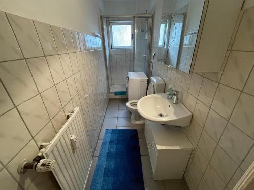 a bathroom with a sink and a toilet and a mirror at Gemütlich & Zentral - Familien-Oase mit Balkon,Waschmaschine, Trockner für 4 Personen in Bremerhaven