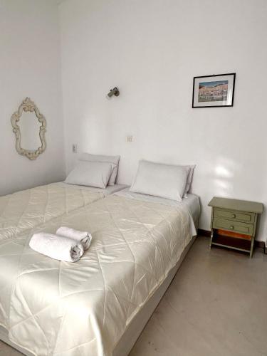 a bedroom with two beds and a side table at Jasmine of Cyclades in Kinion