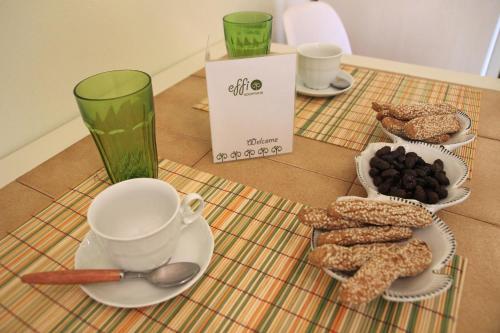a table with a cup and plates of food on it at Effi Apartments in Plataniás