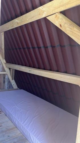 a wooden bunk bed with a purple mattress at Vale do Rio Bonito Glamping in Riozinho