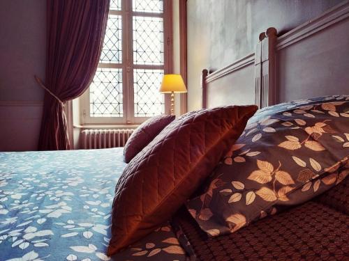 a bedroom with a bed with pillows and a window at Château de Bellevue in Sainte-Cécile