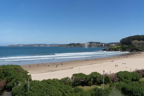 a group of people walking on a beach at AFTER Hotel in Bastiagueiro