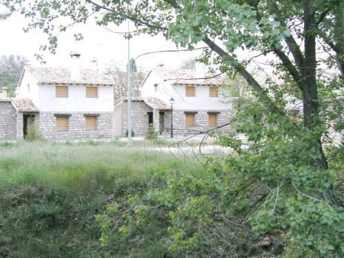 stary kamienny dom pośrodku pola w obiekcie Casa Rural Nelia w mieście Villalba de la Sierra