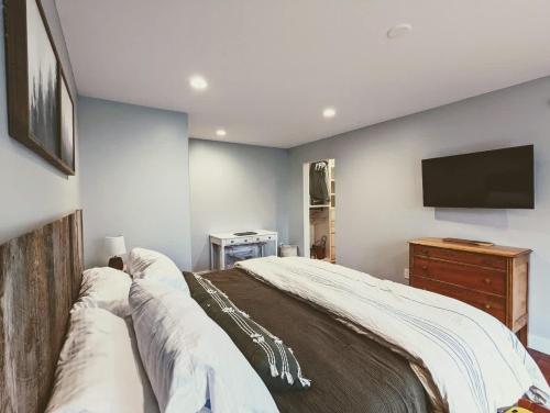 a bedroom with a bed and a flat screen tv at Bar Harbor Hikers Dream in Bar Harbor