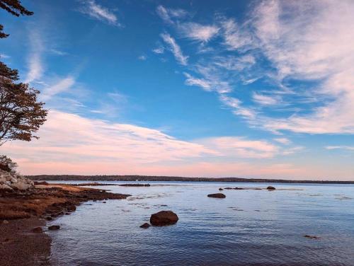 a large body of water with rocks in it at Lone Pine Oceanfront Cottage in Prospect Harbor