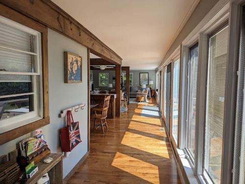 a hallway of a house with wooden floors and windows at Lone Pine Oceanfront Cottage in Prospect Harbor