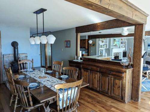 a dining room with a table and a kitchen at Lone Pine Oceanfront Cottage in Prospect Harbor
