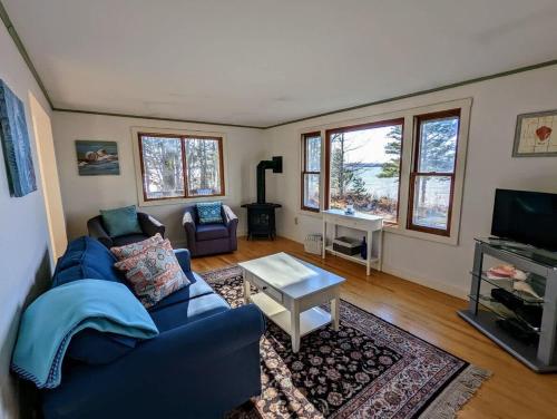a living room with a blue couch and a tv at Tideside Beach House in Trenton