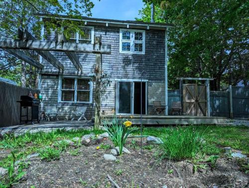a brick house with a porch and a yard at Acadia Park Suites Condo in Southwest Harbor