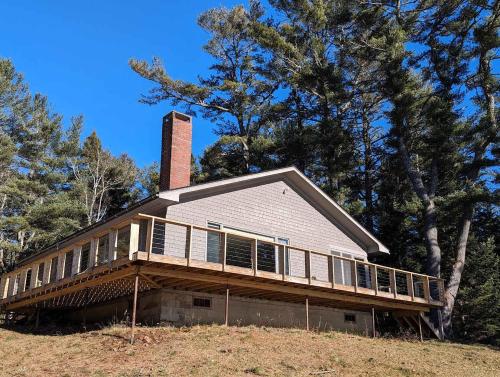 a house on top of a hill with trees at Frenchman Bay Oceanfront Getaway in Sullivan