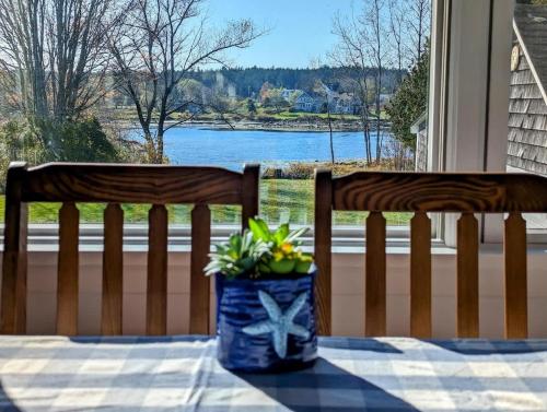 due panche di legno appoggiate su un tavolo con una pianta di NEW Beachy Watering Cove Cottage a Prospect Harbor