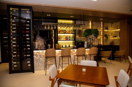 a bar in a restaurant with tables and chairs at Hotel Termas Gravatal in Gravatal