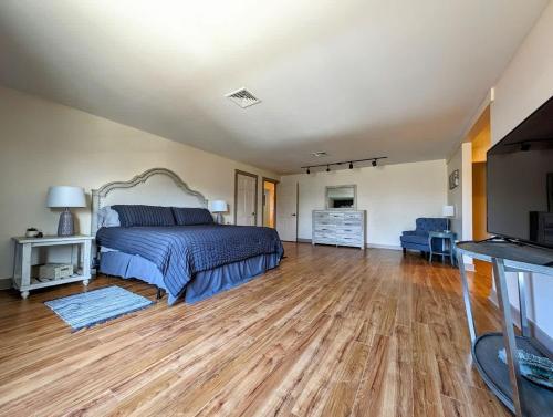 a bedroom with a bed and a wooden floor at Acadia Luxury Penthouse Suite in Trenton