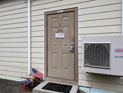 a house with a brown door and an american flag at Acadia Luxury Penthouse Suite in Trenton