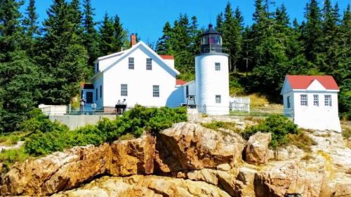 a lighthouse sitting on top of a rocky hill at Acadia Luxury Penthouse Suite in Trenton