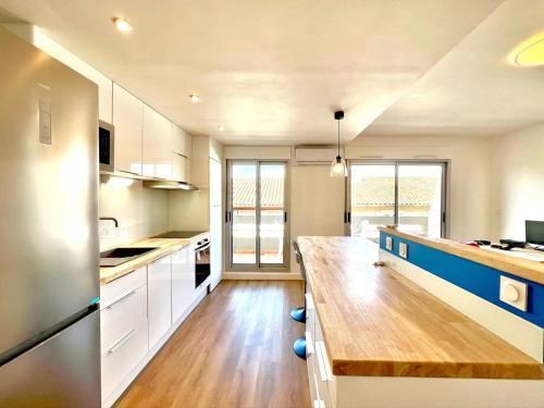 une grande cuisine avec une table en bois. dans l'établissement Le Moderne à Nîmes, proche Arènes et gare, à Nîmes