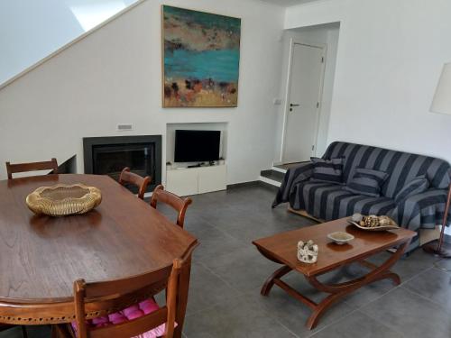 a living room with a table and a couch at Moradia no Meco in Sesimbra