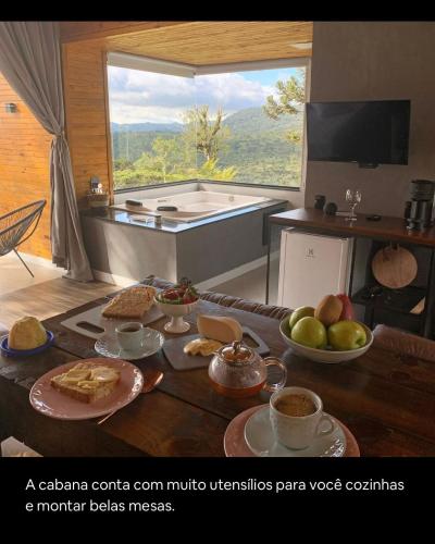 a room with a table with food and a bath tub at Refúgio da Realeza in Urubici