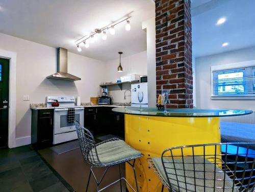 a kitchen with a yellow island in the middle at Acadia Park Suites 1 in Southwest Harbor