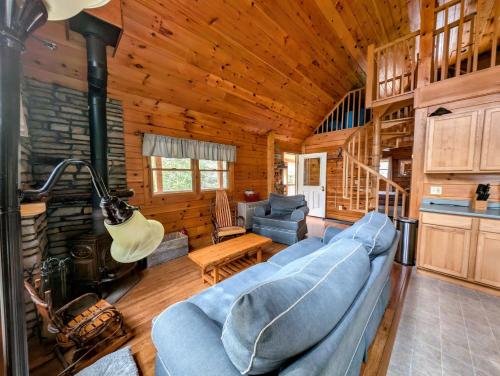 a living room with a blue couch in a log cabin at Log Cabin on Saltwater Cove in Ellsworth