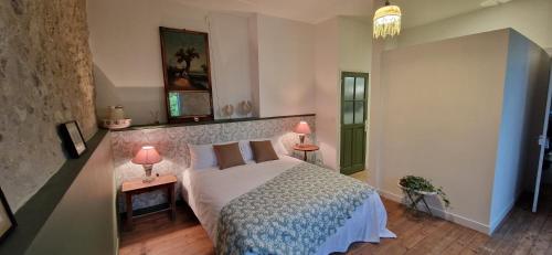 - une chambre avec un lit et 2 tables avec des lampes dans l'établissement Domaine de Bôle , Maison d'Hôtes, à Condom