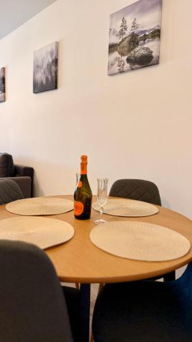 a table with two chairs and a bottle of wine at Deterra Studio 70 next to Metro Station Berceni in Popeşti-Leordeni