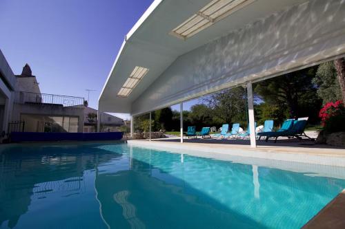 une grande piscine avec des chaises bleues dans l'établissement Villa Domaine des Marais, à Saint-Sornin
