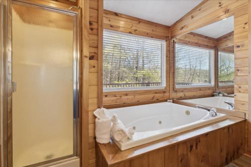 a large bathroom with a tub and a shower at A Dream Romance Cabin With Hot Tub & Fireplace in Sevierville
