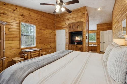 a bedroom with a large bed and wooden walls at A Dream Romance Cabin With Hot Tub & Fireplace in Sevierville