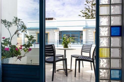 a patio with chairs and a table outside a window at Blue Calm in Daratso
