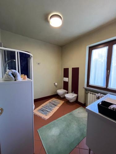 a bathroom with a toilet and a sink and a window at Fuga nella Natura tra Laghi&Golf in Bogogno
