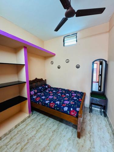 ティルヴァンナーマライにあるMURUGA Homestayのベッドと天井扇風機のある寝室
