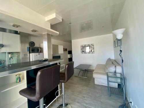 une cuisine et un salon avec une table et des chaises dans l'établissement Le cosy dans la marina de Carnon, à Carnon-Plage