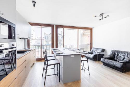 une cuisine et un salon avec une table et des chaises dans l'établissement GuestReady - Stylish Stay in the Heart of Javel, à Paris