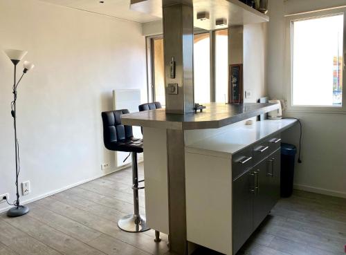 - une cuisine avec un comptoir et une chaise dans une pièce dans l'établissement Le cosy dans la marina de Carnon, à Carnon-Plage