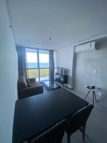 a living room with a table and a couch at Beach Flats Barra Home Stay By Flatbpaiva in Recife