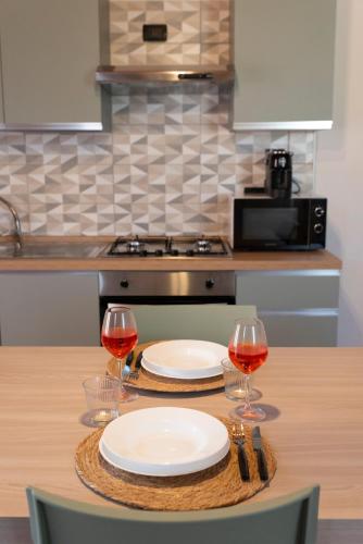 a table with two plates and wine glasses on it at Cà Vecia - Apartments & Rooms in Sottomarina