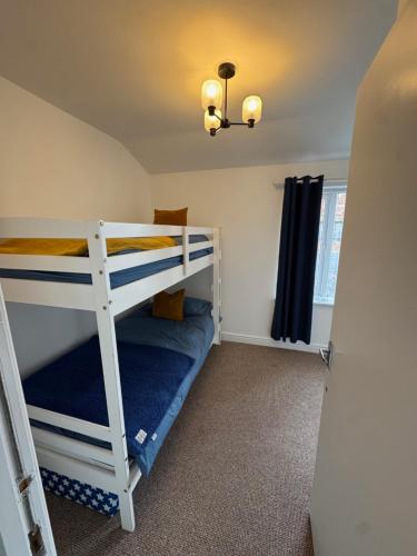 a bedroom with two bunk beds in a room at Valletta House Holiday Apartments in Skegness